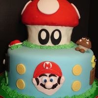 Super Mario Birthday Cake The bottom cake is a 10" round; the top of the mushroom is 1/2 of a ball pan; and the stem of the mushroom is the bottom of the Wilton...