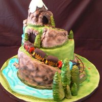 Train On The Mountain Middle two layers are cake, top, base and hills are sculpted from rkt. Cake is covered in fondant and airbrushed.