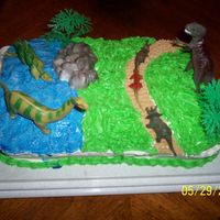 Dinosaur Cake i made this for my nephew who loves dinosaurs. it's a yellow cake mix with buttercream icing. i got the toys at walmart. he loved it...