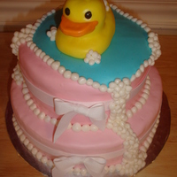Bubbly Ducky 2-tier white cake with pink buttercream filling, fondant covering. Hand sculpted ducky and bubbles. Real ribbons.