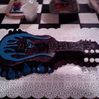 Guitar With Blue Flames This is a devil's food cake with fudge icing. The flames are mmf. This was my very first time making and using mmf. This was also my...