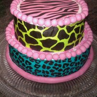Colorful Zebra Print Red velvet cake w/ buttercream frosting. The borders are made of fondant. For the pattern around the cake I used Duff's edible cake...