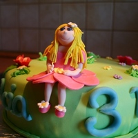 Fairy On A Meadow Cake made with strawberry buttercream. The decoration is all made of fondant. Fairy figurine is gumpaste.