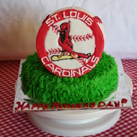 St. Louis Cardinals Baseball This cake was made using the ball pan. It sits upon a 9 inch round. Both are iced in buttercream. The emblem was made using royal icing.