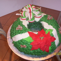 Christmas Wreath Wreath cake,fondant poinsettia,bow and ribbon,leaves buttercream,royal pinecones