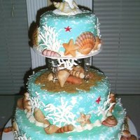 Beach Theme Wedding Cake FONDANT ICED,SHELLS ARE WHITE CHOCOLATE AIR BRUSHED AND HAND PAINTED,CORAL IS ROYAL ICING,SAND IS BROWN SUGAR.