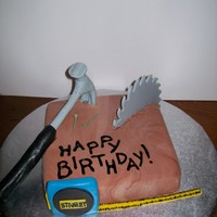 Carpenter's Tools Cake This is a small yellow cake with fondant to make the cake look like a wood block. The tools are made from fondant.