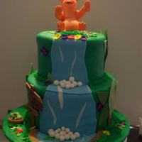 Land Before Time 2 Tier cake covered in buttercream fondant. Yellow Cake with chocolate filling.