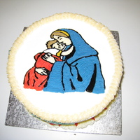 Virgin Mary & Baby Jesus The spice cake was filled with Almond Buttercream. It was decorated with Holly Leaves & berries and a gold ribbon.