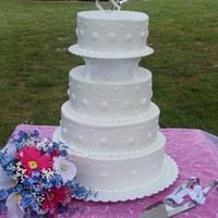 May Wedding This is a 4 tiered round cake for an outside wedding. It is a white cake with buttercream icing.