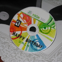 Xbox With Game And Remote xbox and controller are cake covered in fondant. Birthday game is gumpaste painted with gel colors.