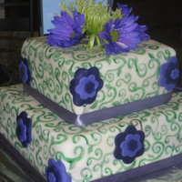 Purple And Green Fondant painted with vodka and food coloring. Fondant flowers on sides. Real flowers on top