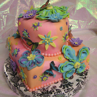 Flower Power Marshmallow fondant-covered carrot cake heart-shaped top tier, vanilla cake with strawberry filling square bottom tier. Gumpaste and...