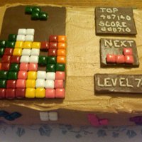 Tetris Tetris board made for grandmothers 78th birthday. Covered cake in brown buttercream. Used chocolate bars with square gum pieces glued on...