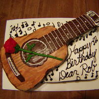 Rob's Guitar Hand carved guitar on top of layered cake. Buttercream rose
