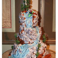 Kayak Grooms Cake this is an off set topsy turvy cake using the wedge method. rocks are MMF and were hand painted for the extra detail