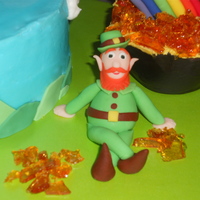 Happy St. Patrick's Day! Additional picture will show the entire cake. Chocolate cake with BC icing and fondant hills. Fondant rainbow and leprechaun. Pot of gold...