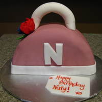 Mini Purse Cake Chocolate cake with strawberry puree, chocolate ganache, choc buttercream and fondant icing. Gumpaste roses & handle.