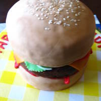 Burger Cake Made with layers of vanilla cake, red velvet, and chocolate cake.With vanilla buttercream, chocolate buttercream, and chocolate ganache/...