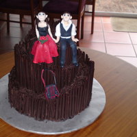 A Red And Black Brides Dress This cake is a 3 tied wedding cake with chocolate cigrellos and is a topsy turvy cake.The bride and groom are made entirely of modelling...