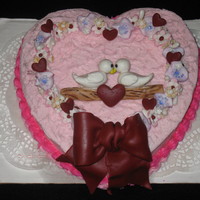 Valentines Day Cake made for valentines day. straweberry cake iced in buttercream with hazlenut banana filling. cake topper is all fondant/gum paste