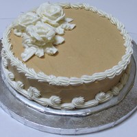 Spice Cake This is a 9 inch round spice cake with peanut buttercream plus vanilla buttercream frosting for the border and flowers.