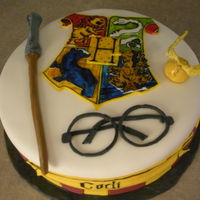 Harry Potter Hogwarts Emblem Cake White cake covered in fondand with handpainted fondant pieces.