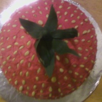 Shyanne's Giant Strawberry Cupcake A Giant Strawberry CupCake made with Buttercream Icing/Red Food Coloring and Pine Nuts for the seeds and Fondant for the stem