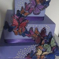 Butterfly Cake 3 tier purple butterfly cake with multi color monarchs cascading up it with yellow dot accents. www.sugarnspicepatisserie.com