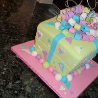 Present Cake Things learned while doing this cake: 1. Do not decorate the board until after the cake is finished. 2. It is really hard to get fondant on...