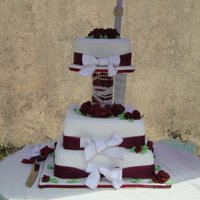 Wedding Cake White fondant with burgundy and green gumpaste flowers and leaves.Burgundy organza and white/ burgundy silk ribbons