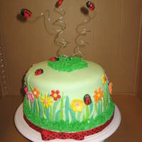 Spring Garden 3 layer yellow cake with lemon and raspberry fillings. Covered with buttercream and fondant. Fondant flowers and ladybugs.