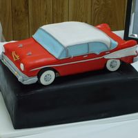 57 Chevy Bel Air 4Door cake shaped like 57 chevy bel air - covered in fondat ; sitting on top of another cake