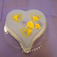 Hearts And Roses Heart cake covered in white fondant with a purple fondant overlay. Three embrodery heart with rosesbuds. Medium roses in center with...