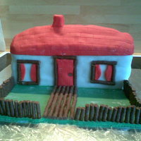 House House covered in fondant with mint chocolate sticks for fence, path and door/window frames