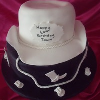 Cowboy Hat vanilla two tiered cake with cowboy hat, boots and mini hats on cake board
