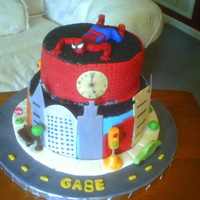 Spider Man Looking Down On The City Spiderman looking down on the city...bottom tier b/c with fondant buildings. Park benches, lights , ect out of modeling chocolate. Black &...