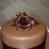 Chocolate Plastique Roses This is a chocolate cake iced with choc ganache, covered with choc fondant and decorated with choc plastique roses and a calla lily.