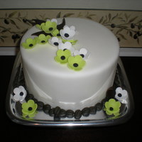 Coffee Beans And Flowers A simple cake with flowers and coffee beans!!! The cake is actually a fondant covered dummy which I later made in to a coffee cup cake.