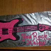 Haley's Guitar Cake 2 chocolate cake sheet cakes cut out in the shape of a guitar cake. buttercream icing and ribbon has the strings.