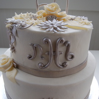 60Th Birthday Cake 8" stacked on 10" chocolate cake with white buttercream icing. Ivory flowers are fondant; silver flowers as well as monogram and...