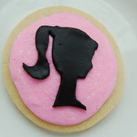 Barbie Silhouette Cookie Rolled sugar cookie iced in pink vanilla buttercream with a hand-but fondant decoration.