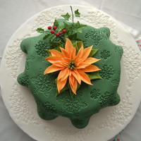 Tablecloth Christmas Cake Rich fruit cake covered with marzipan and a 'tablecloth' of sugarpaste.Poinsettia, holly and ivy made with flowerpaste.