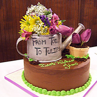 From Toil To Tulips Gardening Retirement Cake: 12-inch Berry Cake with Midnight Ganache filling and frosting, and ligonberry jam filling layer. Watering can is...