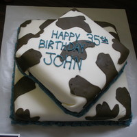 Western Birthday Cake Chocolate cake with buttercream filling, covered in MMF. I used a hat and book cookie cutter for the shapes to make the cow print.