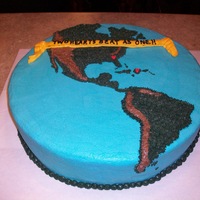 Hearts For Haiti 16 inch round cake with buttercream. North American and South America with Islands included.Continents are dark green with brown mountains...