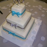 Winter Wonderland Three tier buttercream wedding cake with accents of blue and silver ribbon.