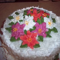 Christmas Cake Yellow cake with whipped icing covered in coconut. Poinsettias are made of royal icing.