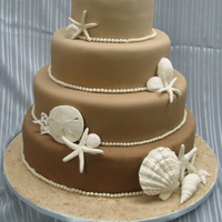 Beach Themed Wedding Cake Taupe cake with handmade gumpaste shells and pearls.