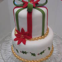 Mini 2 Tier Christmas Cake 4" & 6" tiers covered in white fondant with fondant accents. Bottom layer is handpainted with Americolor gel food coloring....